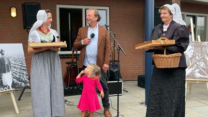 Op het beeld is te zien hoe Spreker Berend Jan Bruggeman (wethouder Goeree-Overflakkee) samen met twee vrouwen in Zeeuwse Klederdracht staat. Er staat nog een klein meisje voor Jan. Jan heeft een microfoon vast en de vrouwen in klederdracht hebben een dienblad vast met daarop Kruukplaetjes en Bolussen.